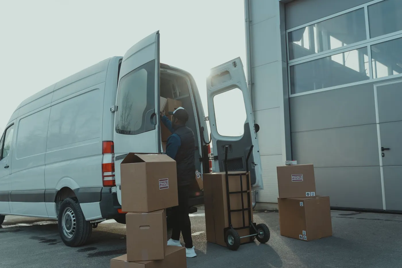 Umzugshelfer belädt einen weißen Transporter mit Kartons