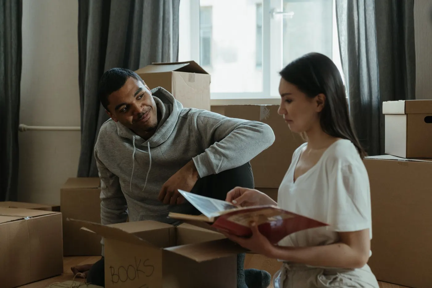 Paar zwischen Umzugskartons in der neuen Wohnung